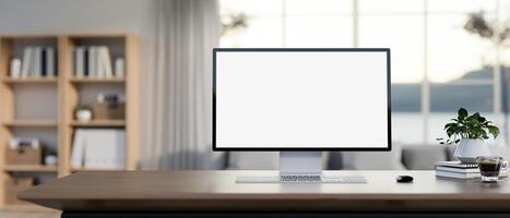 ein weißer Bildschirm Computer Attrappe, Lehrmodell, Simulation auf ein hölzern Schreibtisch im ein zeitgenössisch Leben Zimmer. foto
