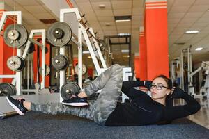 schön schlank Brünette tun etwas Dehnen Übungen im ein Fitnessstudio. foto