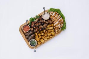 die meisten Fleisch Gericht - - Rindfleisch Kebabs, Würste, gegrillt Pilze, Kartoffeln, Tomaten und Soße. das Beste Wahl zum ein Bier. Nahansicht auf ein Weiß Hintergrund foto