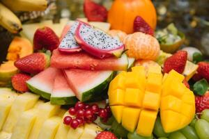 frisch organisch Früchte Hintergrund. gesund Essen Konzept. frisch, exotisch, organisch Früchte, Licht Snacks im ein Teller auf ein Buffet Tabelle foto
