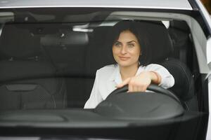 Foto von glücklich jung Frau Sitzung Innerhalb ihr Neu Wagen. Konzept zum Auto Vermietung