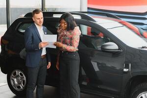 Frau Kauf das Wagen. Dame im ein Auto Salon. elegant schwarz Mädchen foto