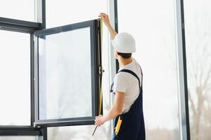 bauarbeiter, der fenster im haus installiert foto