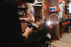 Besuch Friseurladen. afrikanisch amerikanisch Mann im ein stilvoll Barbier Geschäft foto