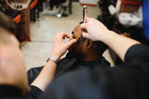 schwarz Mann im das Friseurladen. süß schwarz Mann macht ein Haarschnitt im das afrikanisch Salon. Haar Stil. Haarschnitt zum Erwachsene. foto