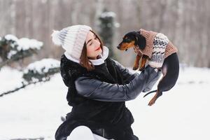 Frau ist Gehen während Winter mit ihr Hund foto