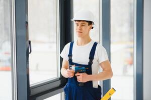 männlich industriell Baumeister Arbeiter beim Fenster Installation im Gebäude Konstruktion Seite? ˅ foto