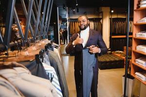 afrikanisch amerikanisch Mann, Kleidung speichern, wählt Kleider foto