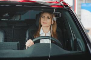 Foto von glücklich jung Frau Sitzung Innerhalb ihr Neu Wagen. Konzept zum Auto Vermietung.