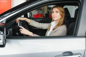 Foto von glücklich jung Frau Sitzung Innerhalb ihr Neu Wagen. Konzept zum Auto Vermietung.