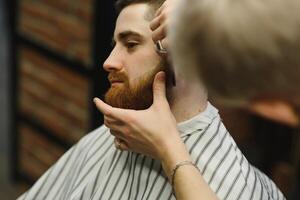 schließen oben Bild von Barbier Rasieren ein Mann mit ein Scharf Stahl Rasierer foto