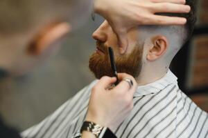 schließen oben Bild von Barbier Rasieren ein Mann mit ein Scharf Stahl Rasierer foto