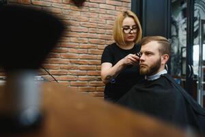 Barbier Frau Schneiden Mann Haar beim das Friseurladen. Frau Arbeiten wie ein Friseur. klein Geschäft Konzept foto