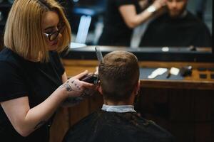 Barbier Frau Schneiden Mann Haar beim das Friseurladen. Frau Arbeiten wie ein Friseur. klein Geschäft Konzept foto