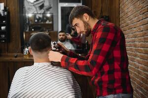 ernst jung bärtig Mann bekommen Haarschnitt durch Barbier. Friseur Thema. foto