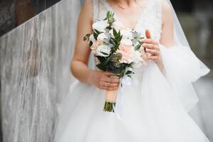 Braut hält ein Hochzeit Strauß, Hochzeit Kleid, Hochzeit Einzelheiten. foto