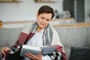 Senior Frau lesen Buch beim heim. foto