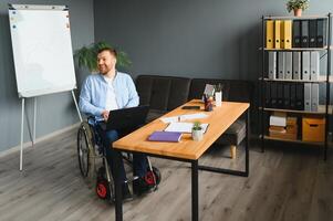 jung glücklich Unternehmer im Rollstuhl Arbeiten auf Laptop beim Zuhause foto