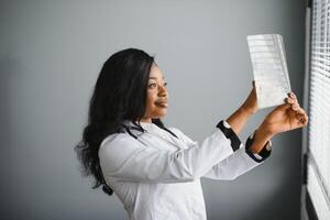 Gesundheitspflege, medizinisch und Radiologie Konzept - - afrikanisch Arzt suchen beim Röntgenstrahlen. foto