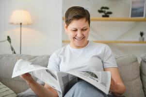 Frau lesen Zeitung beim Zuhause foto