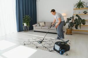 Reinigung Konzept. Frau Reinigung Teppich mit Vakuum Reiniger. foto