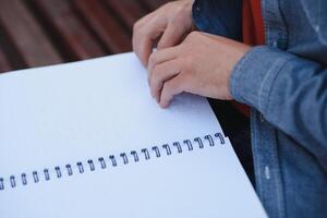 blind Mann lesen Blindenschrift Buch, Sitzung auf Bank im Sommer- Park, ruhen foto