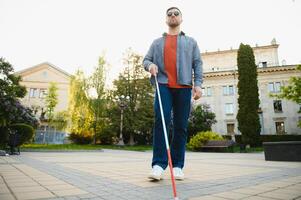 Nahansicht von ein blind Mann Stehen mit Weiß Stock auf Straße foto