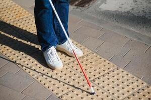 Nahansicht von ein blind Mann Stehen mit Weiß Stock auf Straße foto