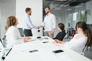 ein Gruppe von Geschäft Menschen Partner während ein einstellen Mannschaft Treffen im das modern Büro. Zusammenarbeit Konzept foto
