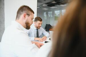 ein Gruppe von Geschäft Menschen Partner während ein einstellen Mannschaft Treffen im das modern Büro. Zusammenarbeit Konzept foto