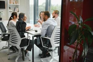 ein Gruppe von Geschäft Menschen Partner während ein einstellen Mannschaft Treffen im das modern Büro. Zusammenarbeit Konzept foto