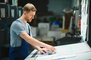 Mann Arbeiter Messung Drucken Farbe mit Spektrometer auf das Betriebs Schreibtisch von das Drucken Pflanze foto