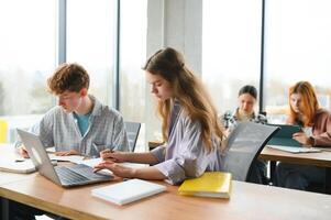 Gruppe von Hochschule Studenten mit Laptop im das Bibliothek foto