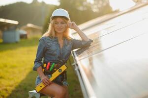 Frauen Ingenieur Arbeiten auf Überprüfung Überprüfung Status Ausrüstung beim Solar- Leistung Pflanze. Frau Arbeiten auf draussen beim Solar- Leistung Pflanze foto