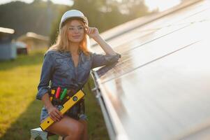 Frauen Ingenieur Arbeiten auf Überprüfung Ausrüstung beim Grün Energie Solar- Leistung Pflanze Überprüfung Solar- Panel und Struktur mit Tablette Checkliste foto