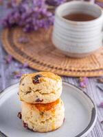 Nahansicht von traditionell britisch Scones Dessert auf ein Teller mit ein Teetasse und Blume verschwommen Hintergrund. Raum zum Text. Konzept von Dessert und Tee foto