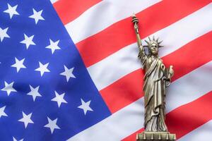 ein Replik von das Statue von Freiheit platziert auf das USA Flagge. Dort ist Beleuchtung auf das Seite von das Statue. 4 .. von Juli, feiern amerikanisch National Tag, Arbeit Tag, Unabhängigkeit Tag, Denkmal Tag foto