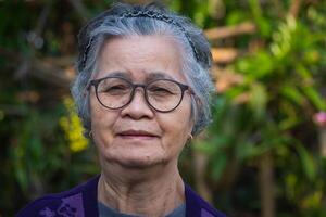 Porträt von ein Senior Frau im ihr Garten. foto