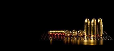 Pistole Patronen 9 mm auf ein glatt glänzend Oberfläche mit Reflexionen. Munition zum Pistolen und pcc Karabiner auf ein dunkel zurück. foto