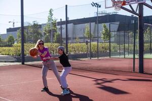 ein glücklich Mutter und Kind Tochter draußen beim Basketball Gericht. foto