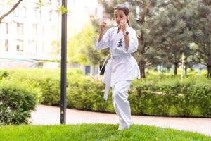 jung Mädchen im ein Weiß Kimono, Karate foto