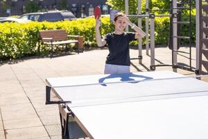 Mädchen Theaterstücke im Tabelle Tennis draussen foto