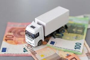Weiß Spielzeug LKW auf Euro Banknoten. Konzept zum Logistik, Transport und und Finanzen foto