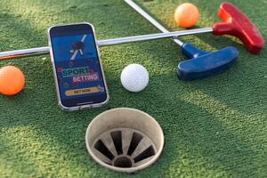 Golf Ausrüstung auf das Grün Rasen. Mini Golf Sport Wetten auf ein Smartphone foto