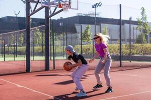 ein glücklich Mutter und Kind Tochter draußen beim Basketball Gericht. foto