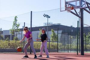 ein glücklich Mutter und Kind Tochter draußen beim Basketball Gericht. foto