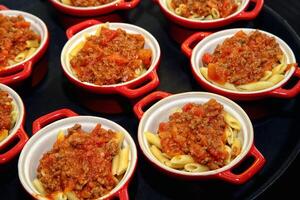 Töpfe mit Penne Bolognese Soße foto