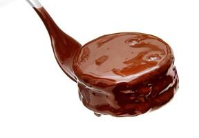 Schokolade Sirup tropft von Löffel foto