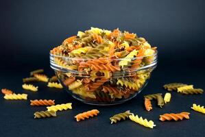 Italienisch Fusilli Einfügen im Glas Schüssel auf schwarz Hintergrund. Nahansicht. selektiv Fokus. foto