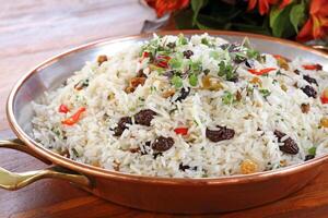 Reis mit Rosinen und Gemüse auf ein Teller foto